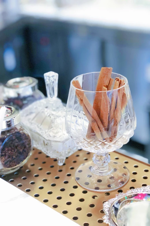 a small clear glass vase with cinnamon sticks inside of it