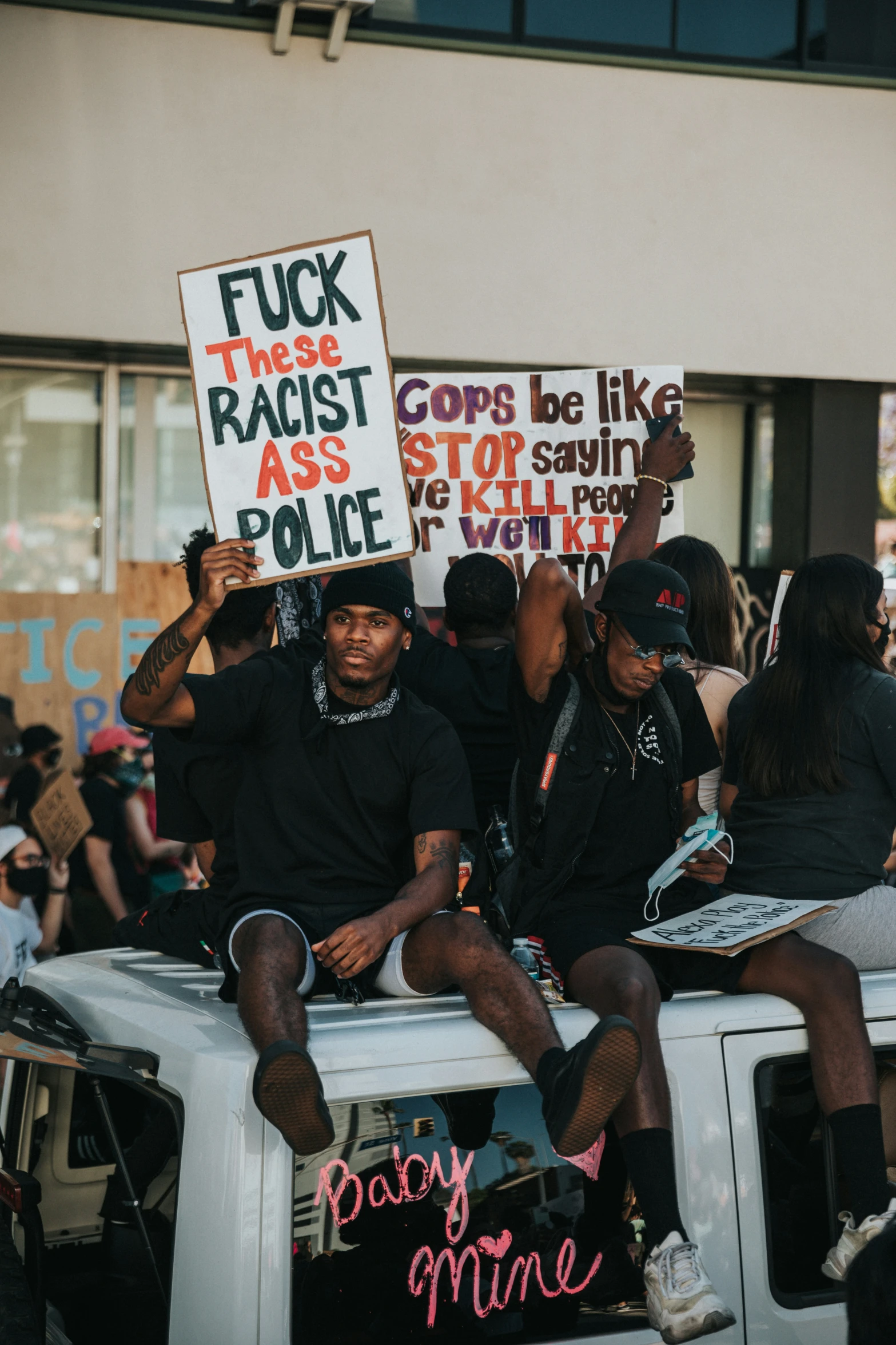 two people sitting on the back of a truck in protest