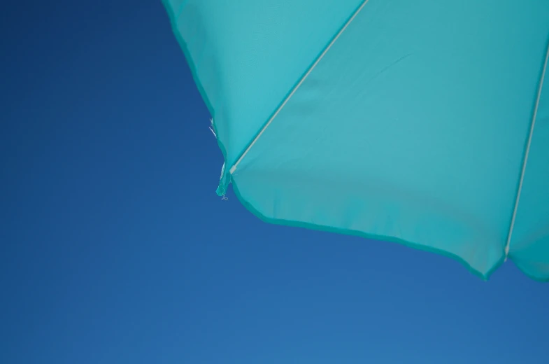 the bottom half of an umbrella against a blue sky