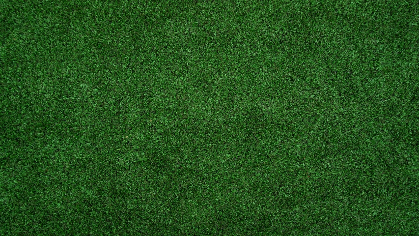 a field of green grass in the middle of it