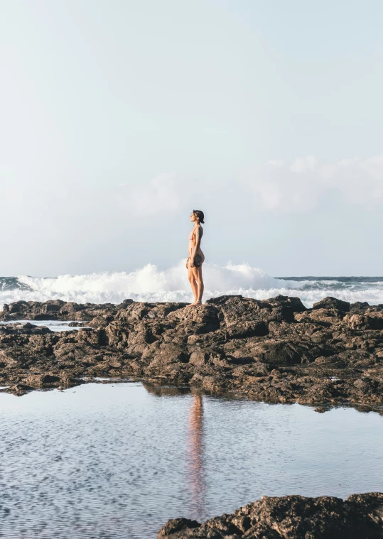 a person is standing on some rocks and water