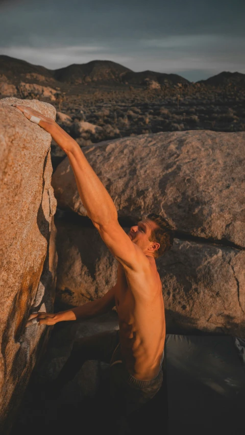 a man climbing up a steep rock in the desert