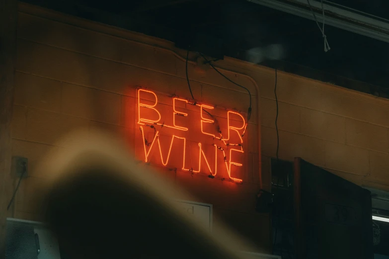 a neon sign reading beer wine hanging from the wall