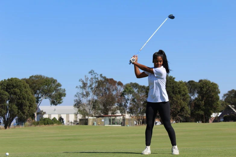 woman playing in outdoor game of golf on grass