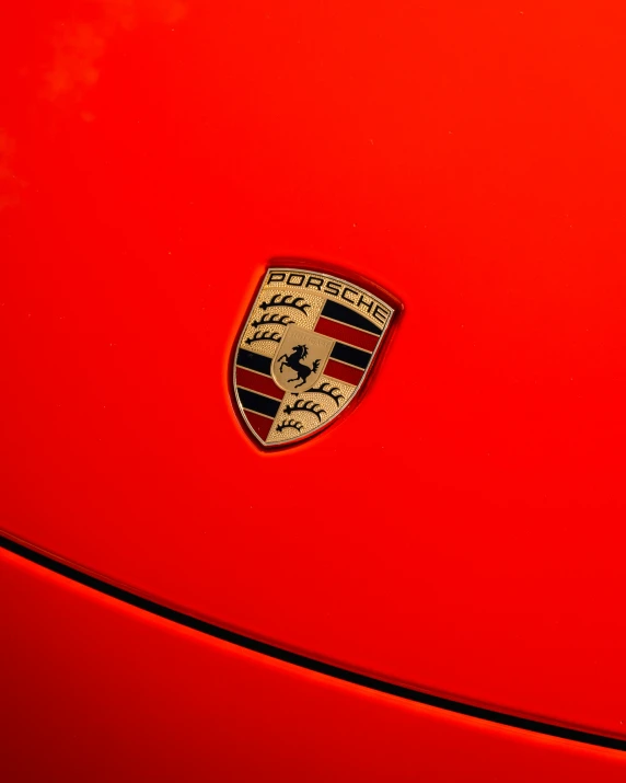 the emblem on the front of a red porsche car