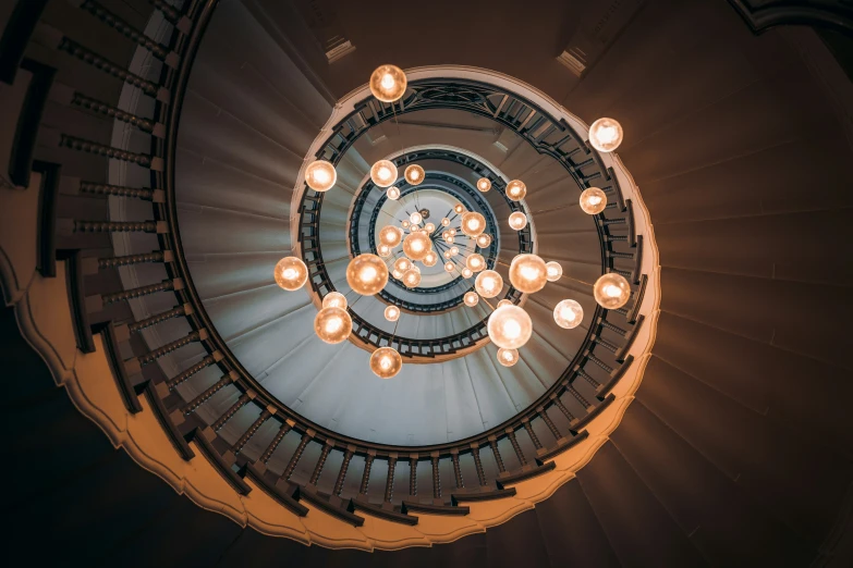 the spiral stair way in a building, with light bulbs shining in it