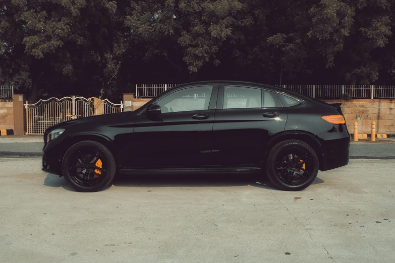 a black car with yellow wheels parked in a parking lot