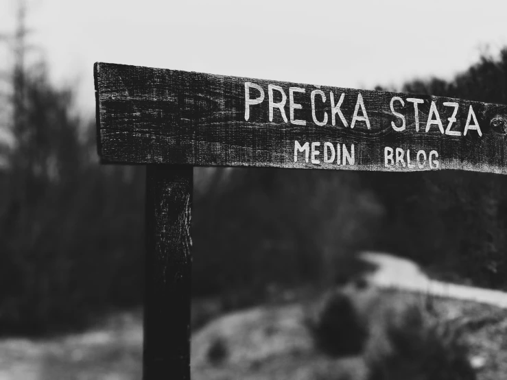 a wooden sign that says peccka - staza in two languages