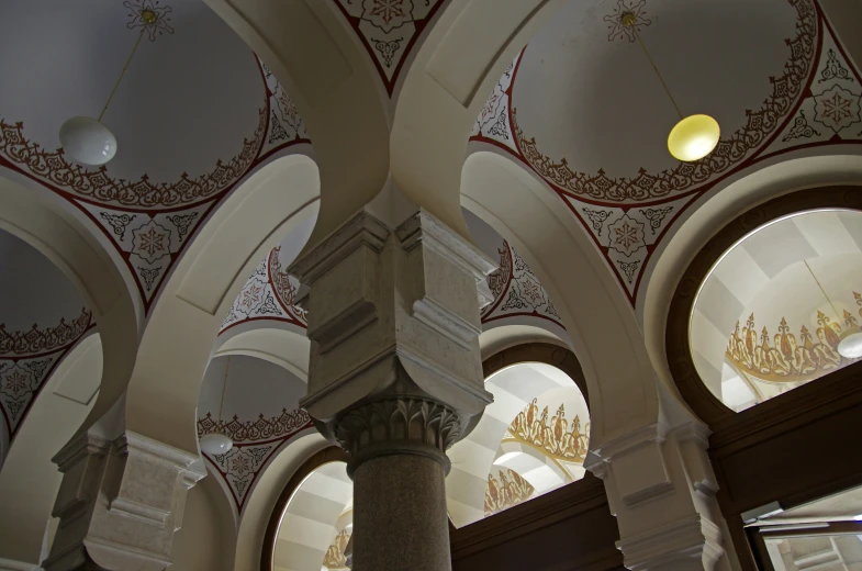 the ceilings and pillars inside of a building with chandeliers