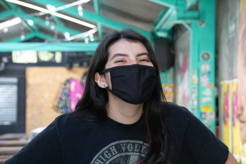 a woman with long hair wears a mask on her face