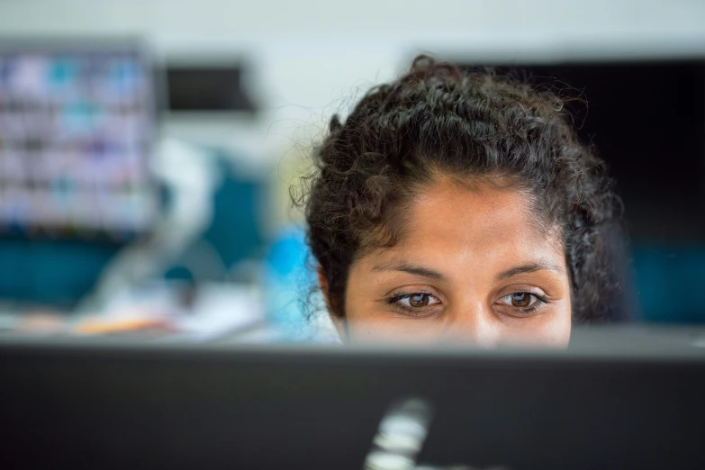 a woman staring at the camera in front of a monitor