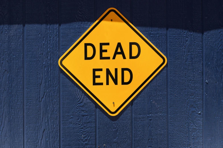 a sign reading dead end on a blue and white wall