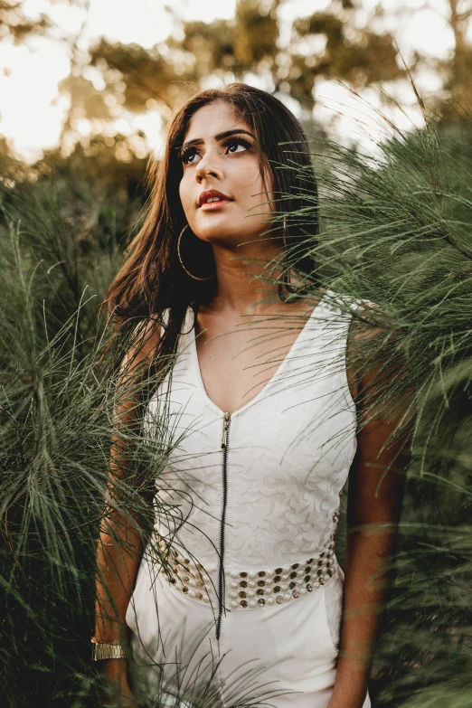 a woman standing in front of a bunch of grass