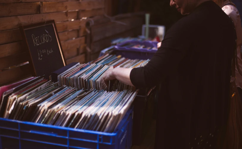 a man sorting records from a bin in an outdoor record store