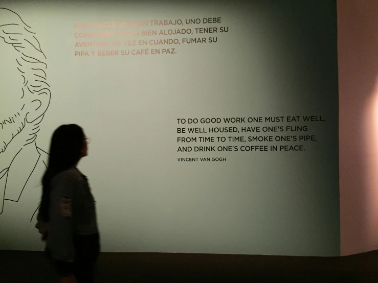 woman looking up at an art piece on display in front of her