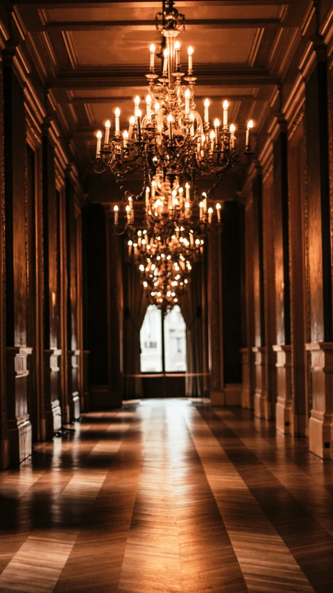 a chandelier hangs from a grand staircase in a fancy mansion