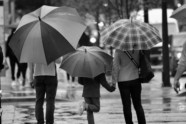a black and white po of people holding umbrellas