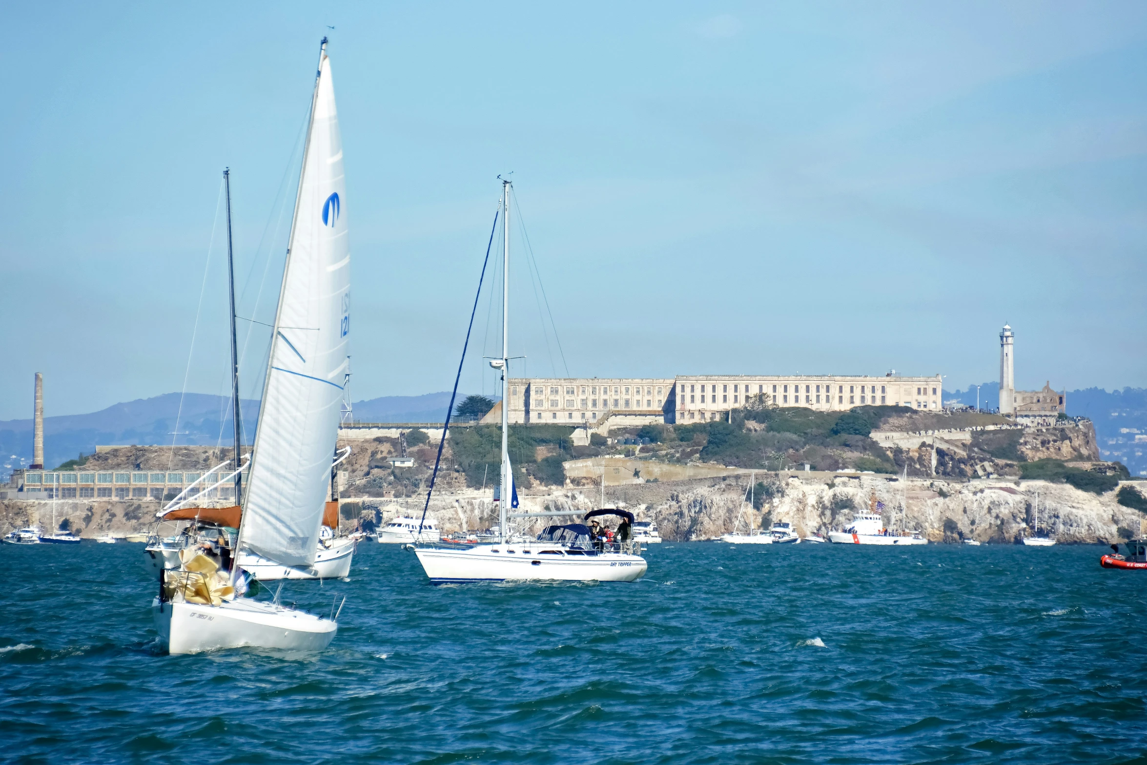 a white sail boat is on the water