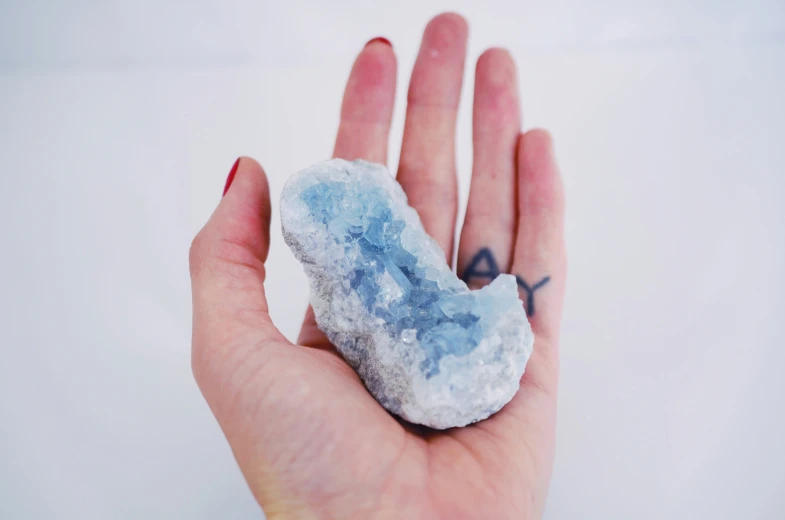 a piece of blue and white quartz sitting in someone's hand