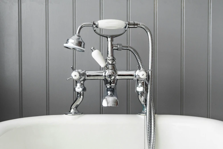 an old fashioned bathtub with chrome taps in a bathroom