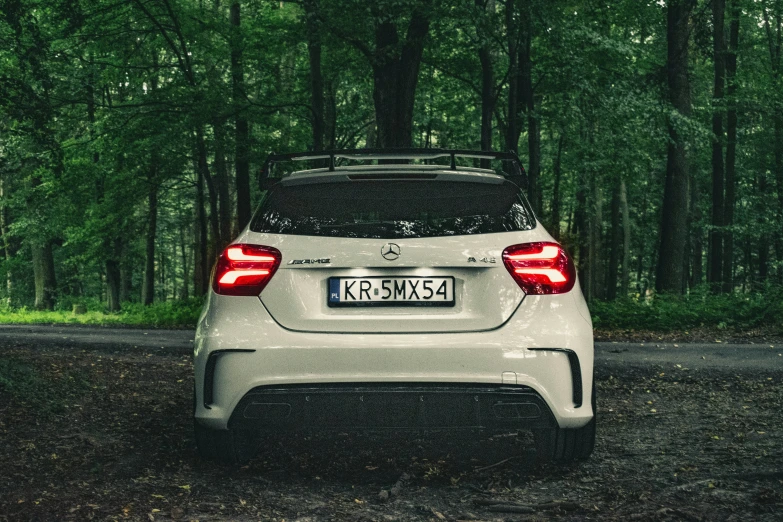 a car parked on the side of a road in the woods