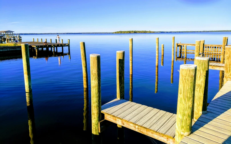 the water is blue with small wooden pillars