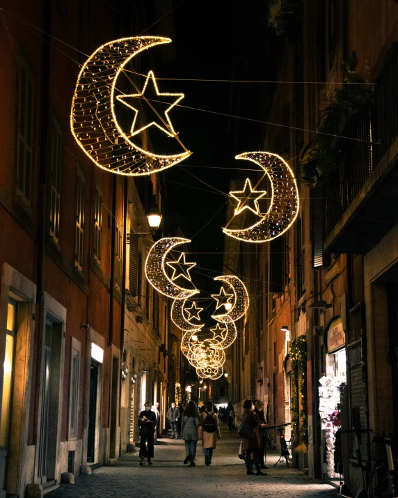 the street has lite up christmas lights on the sidewalk