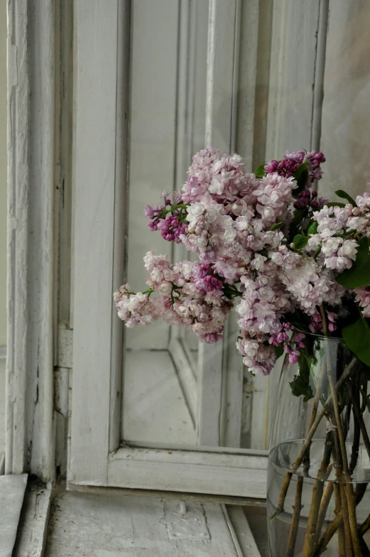 a vase with flowers in it sitting by the window