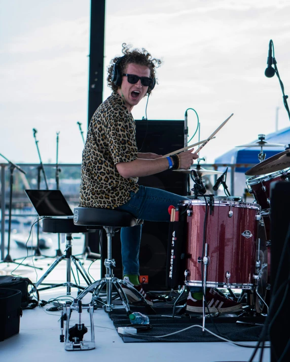 a man sits at the stage with a drum set in front of him