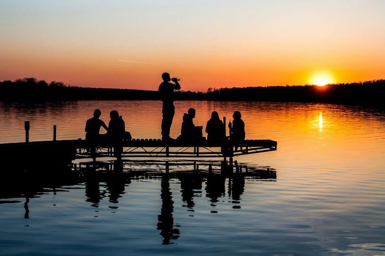 a man is standing on the dock while people sit