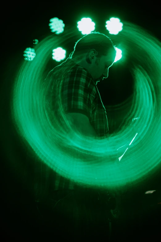 a man spins a circular green light around his body