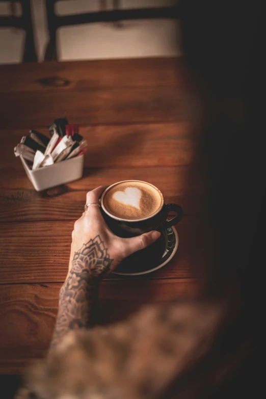 a person sitting at a table with a cup of coffee