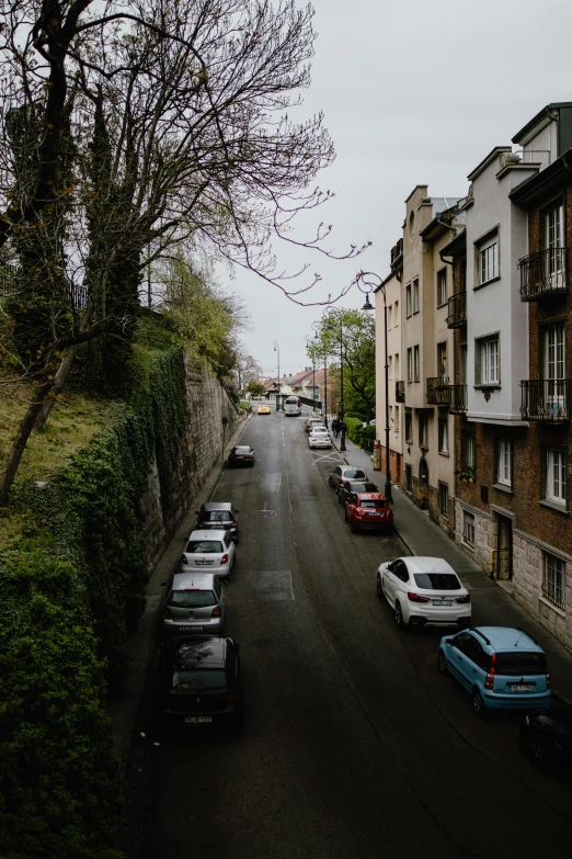 the cars are parked on the street near the buildings