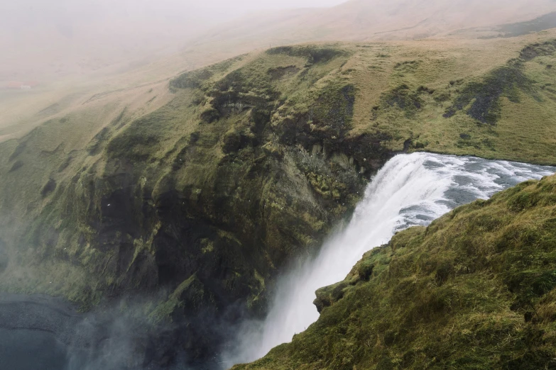 a large waterfall with mist in the sky