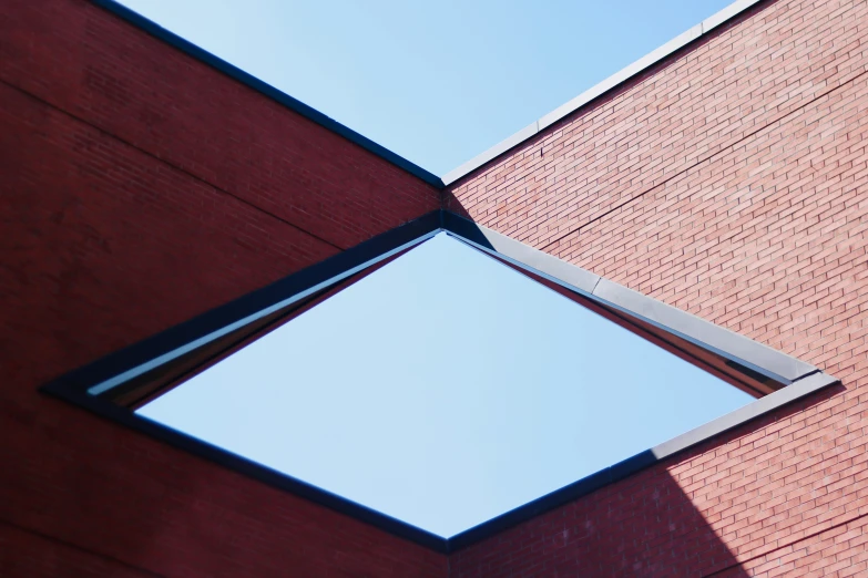 an open window with brick wall with sky in background