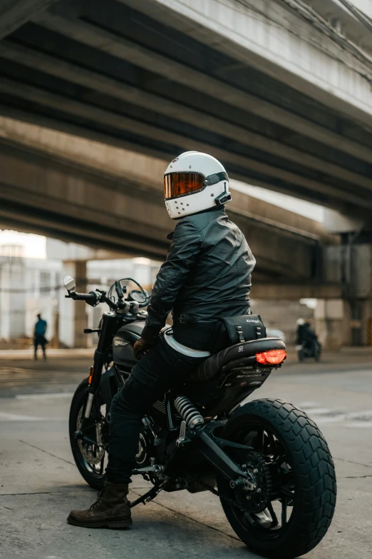 a person in black is sitting on a motorcycle