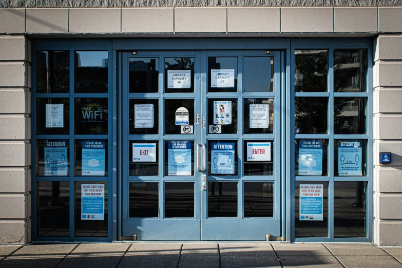 a large, blue door with lots of windows has advertits taped to it