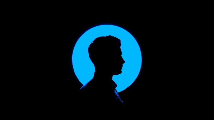 a man standing in front of a dark blue circle