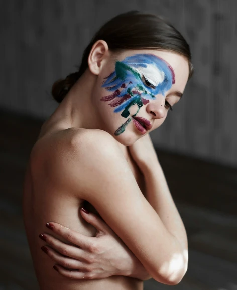 a  woman has an artistic face paint applied to the image