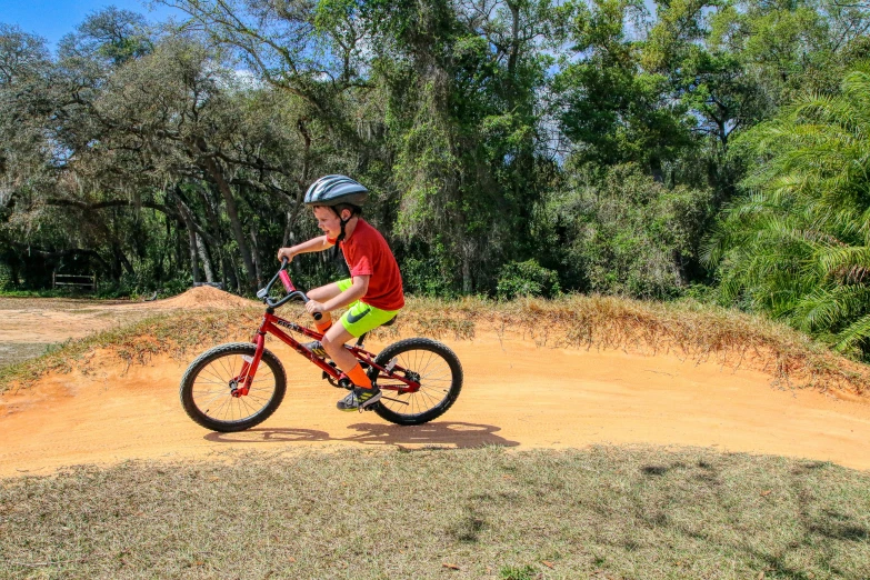 a person in red shirt and green pants riding a bike