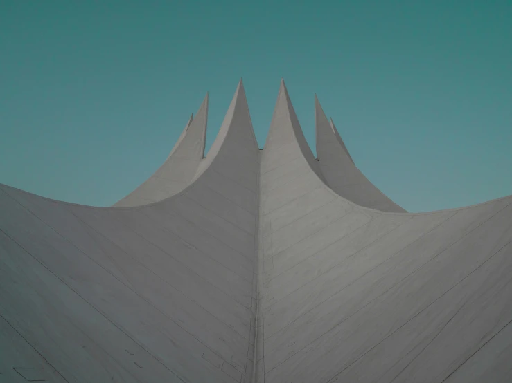 a large building made of gray concrete with a blue sky in the background