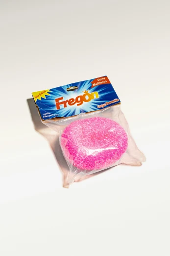 a small round pink toothpaste next to a box of freego