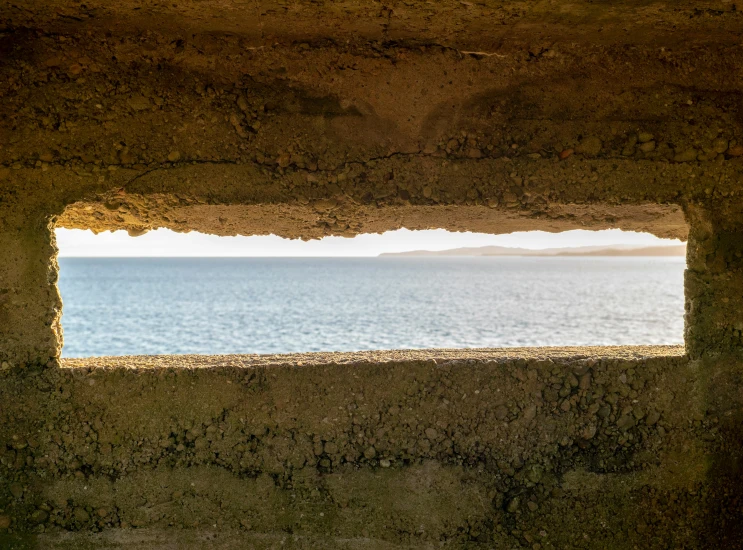 a window that has been partially open showing the ocean