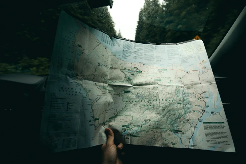 someone's hands hold the map of the area