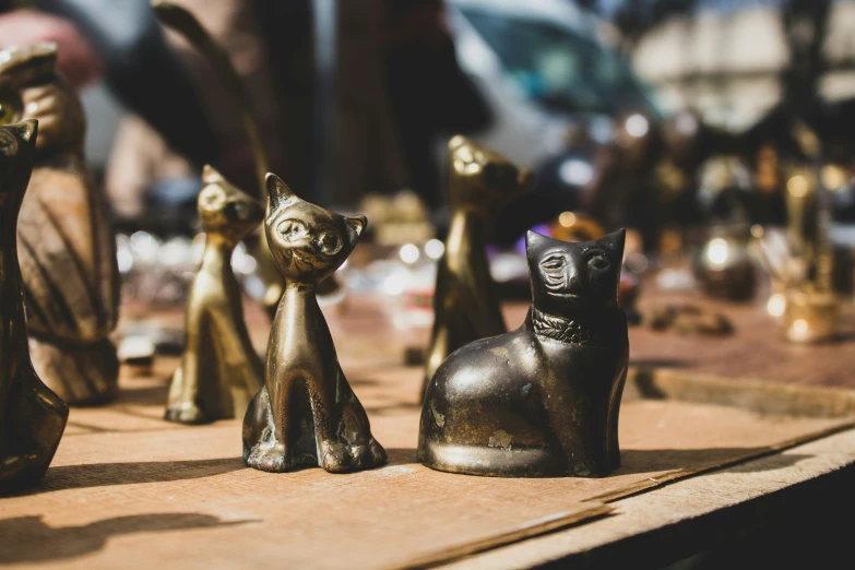 a few statues of cats sitting on a table