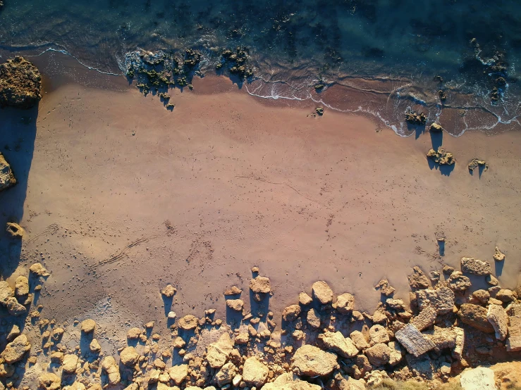 an aerial view of a beach and rocky shoreline