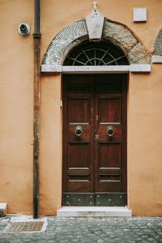 a large wooden door sitting between two tall buildings