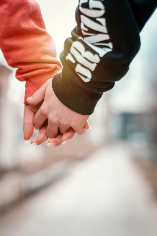 a close up of two people holding hands