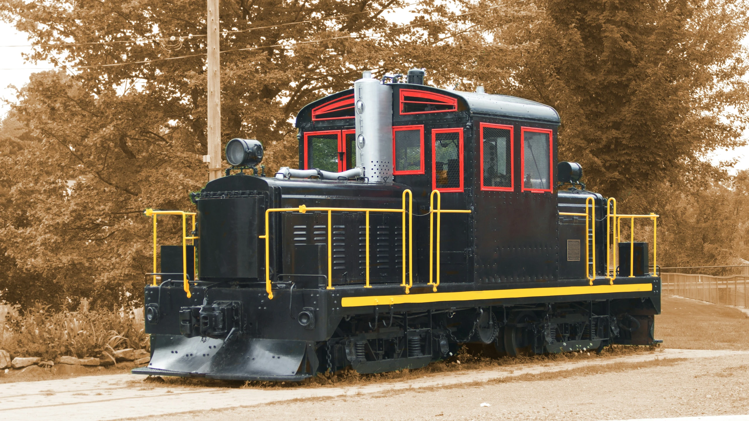 a very colorful train going on a track with trees in the background