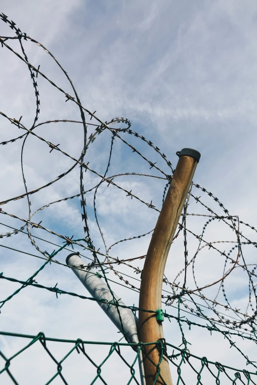 a view through a fence with razor wire